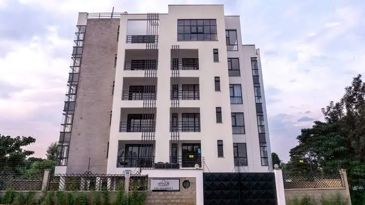 Multi-story residential building facade with balconies and gate