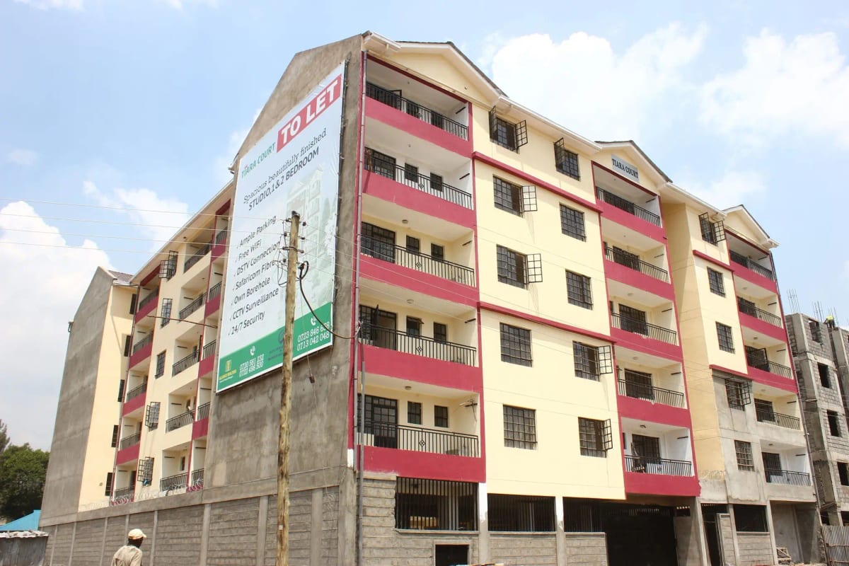 Multi-story residential building facade with pink and cream panels