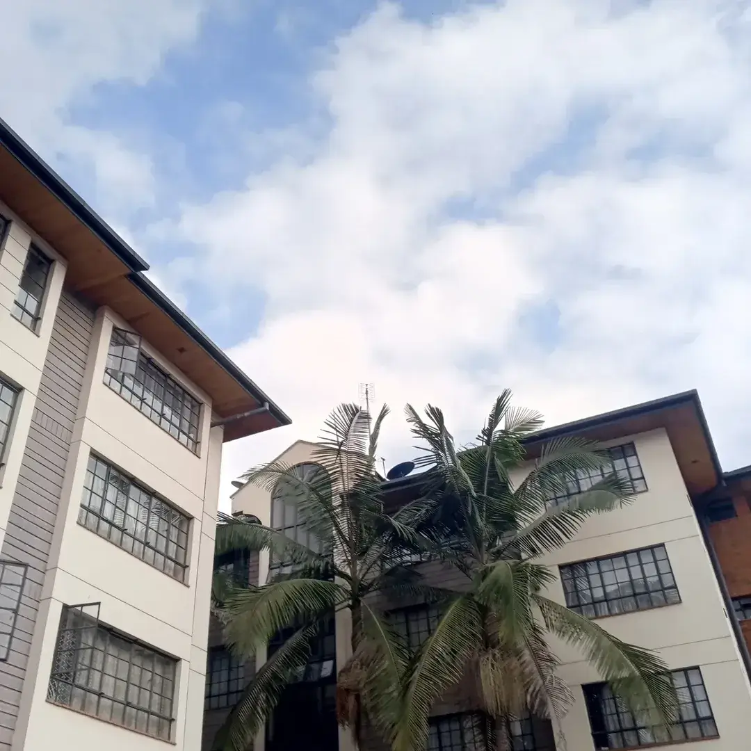Multi-story residential building facade with palm tree courtyard
