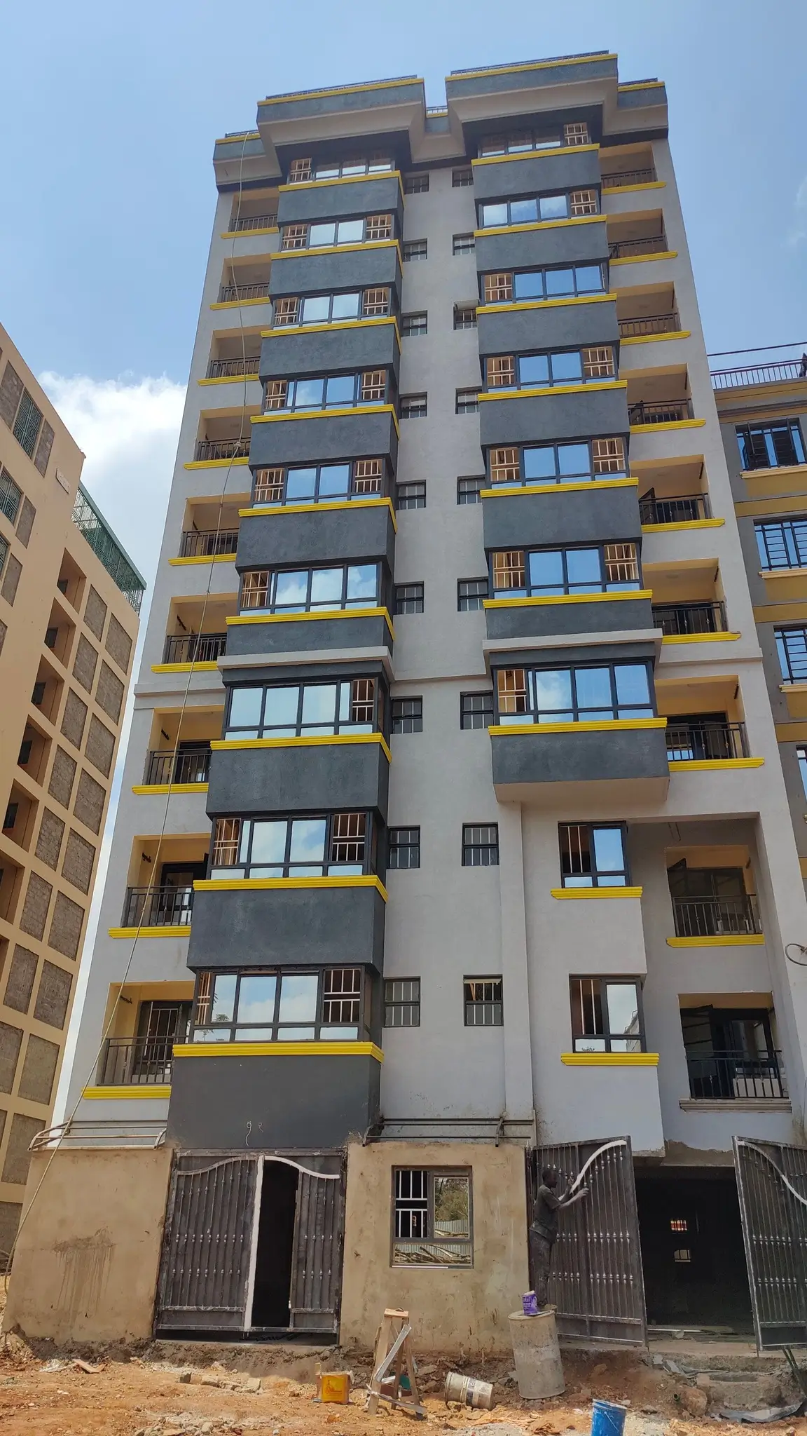 Modern multi-story residential building with yellow balconies