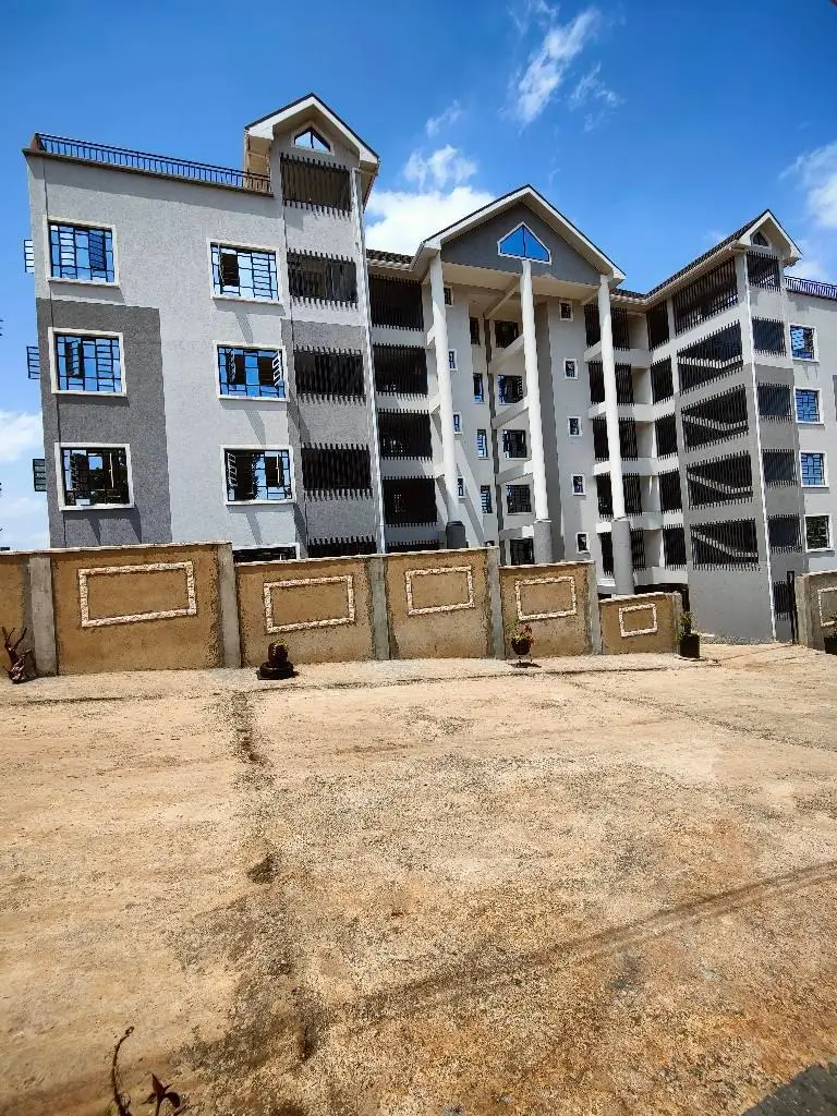 Multi-story residential building with fenced compound entrance