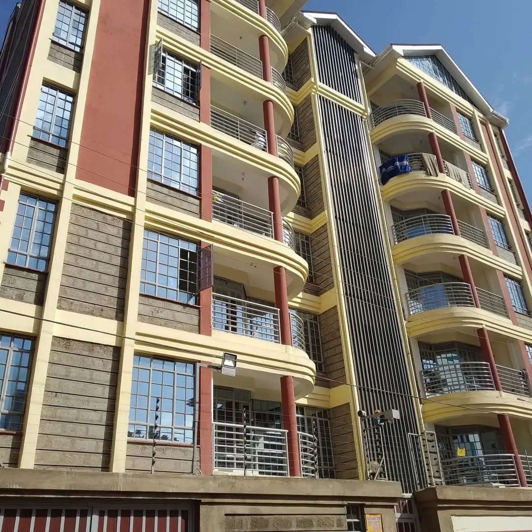 Multi-story residential building facade with cream and red trim