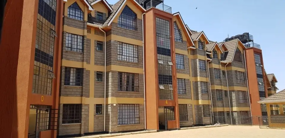 Multi-story residential building facade with orange and cream finish