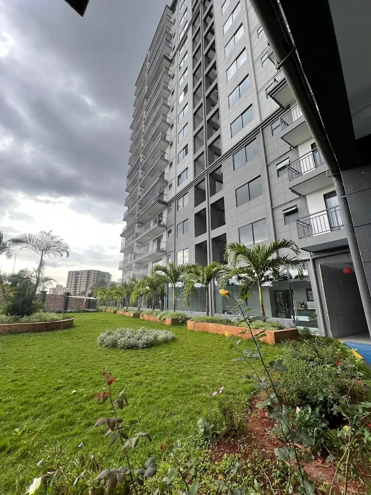 Manicured compound grounds with green lawn and young plantings
