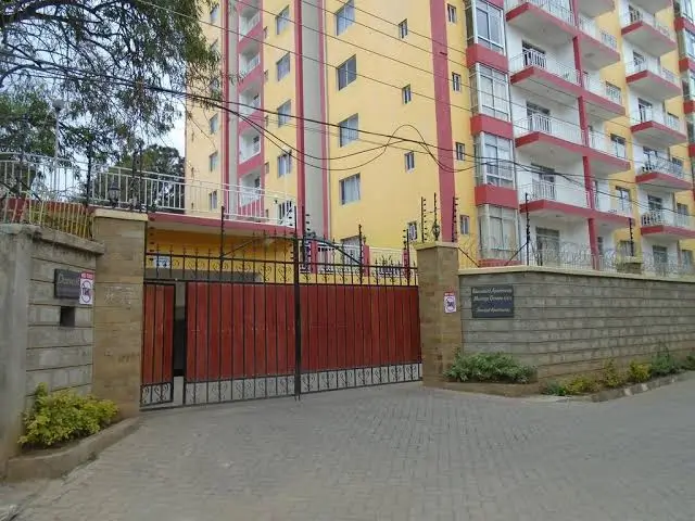 Residential compound entrance with red metal gates and walls