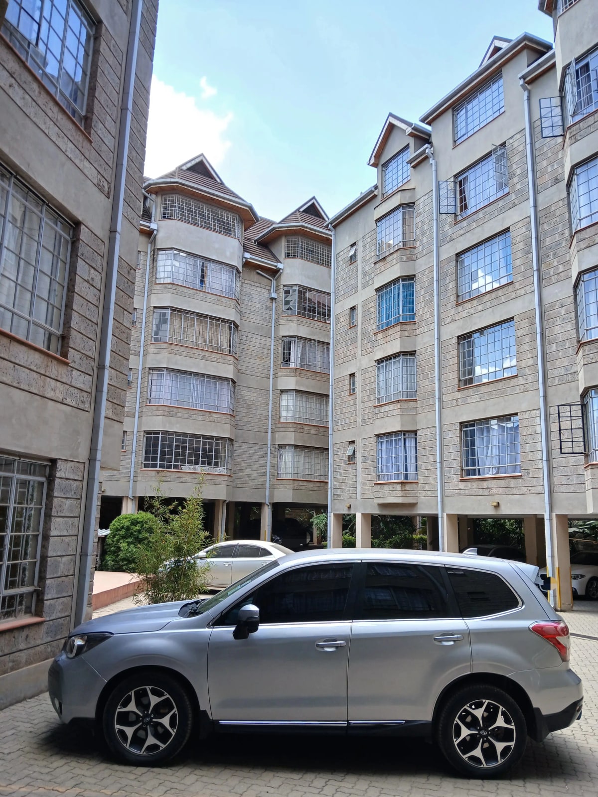 Residential compound parking area with multi-story apartment buildings