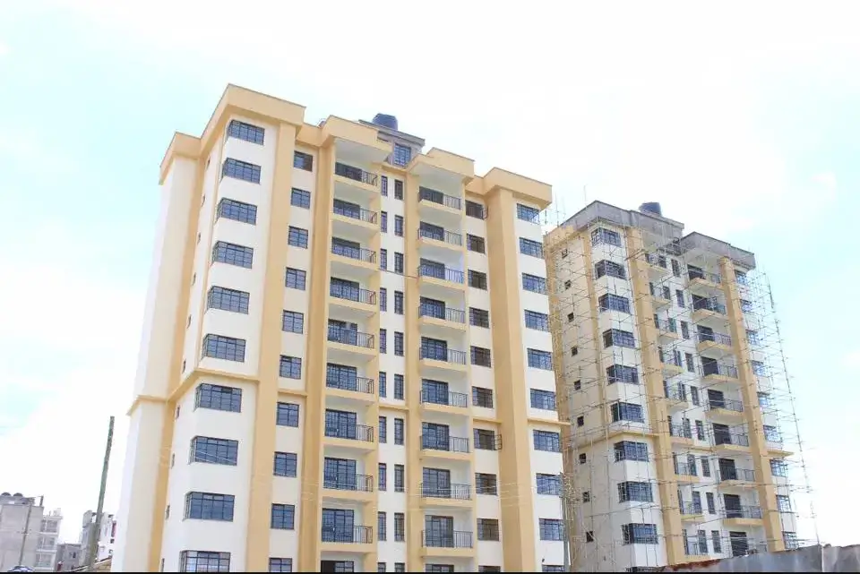 Multi-story residential building facade with yellow/cream exterior