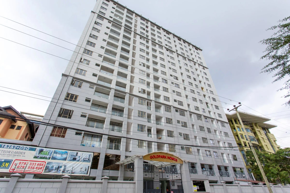 Modern residential apartment building facade with ground-floor commercial signage