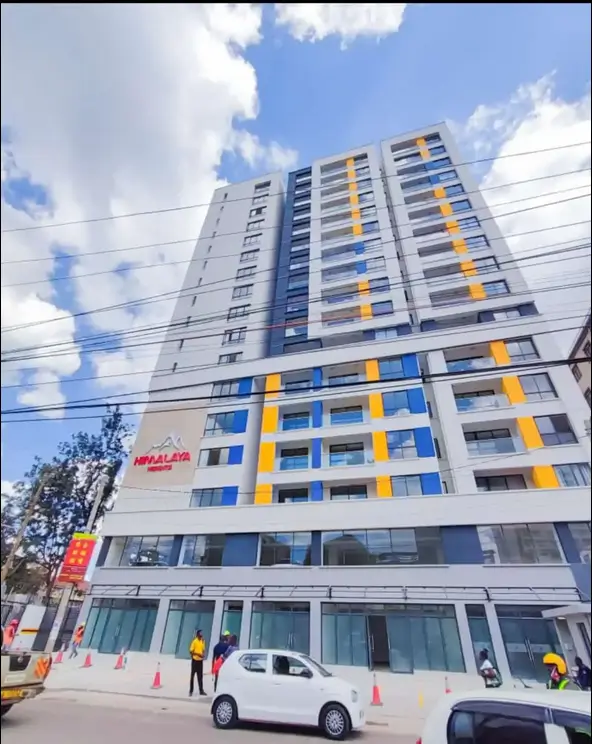 Modern multi-story residential building with blue and yellow accents