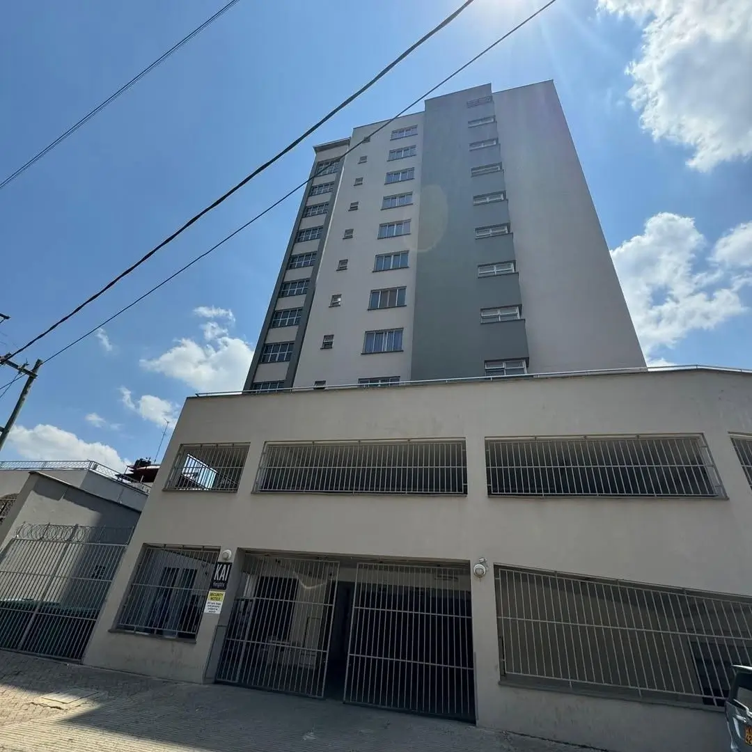 Multi-story residential building with ground-level parking bays