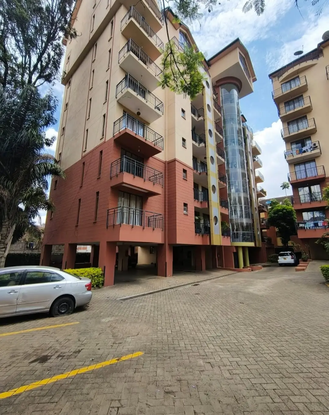 Modern multi-story residential building with red brick base and balconies