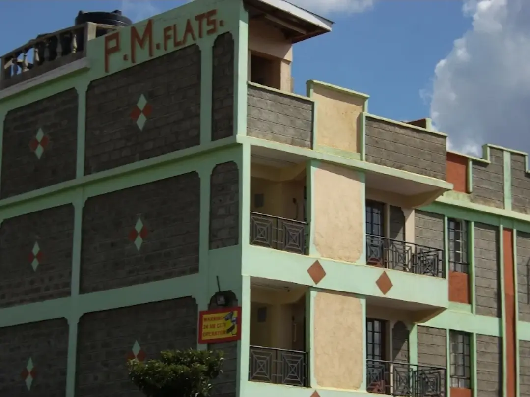 Multi-story apartment building facade with green trim and balconies