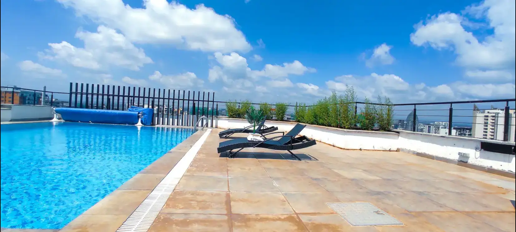 Rooftop infinity pool with loungers and city skyline views