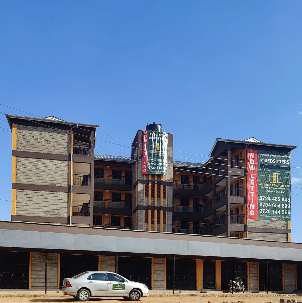 Multi-story residential building facade with ground-floor parking