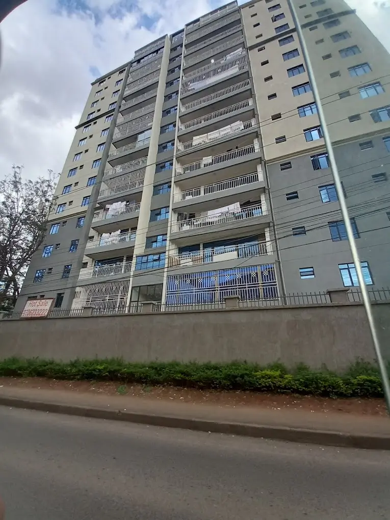 Multi-story residential building facade with balconies and street view