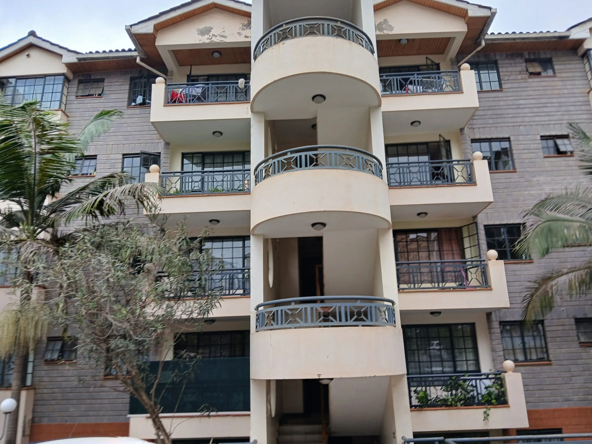 Modern multi-story apartment building with curved balconies and landscaping