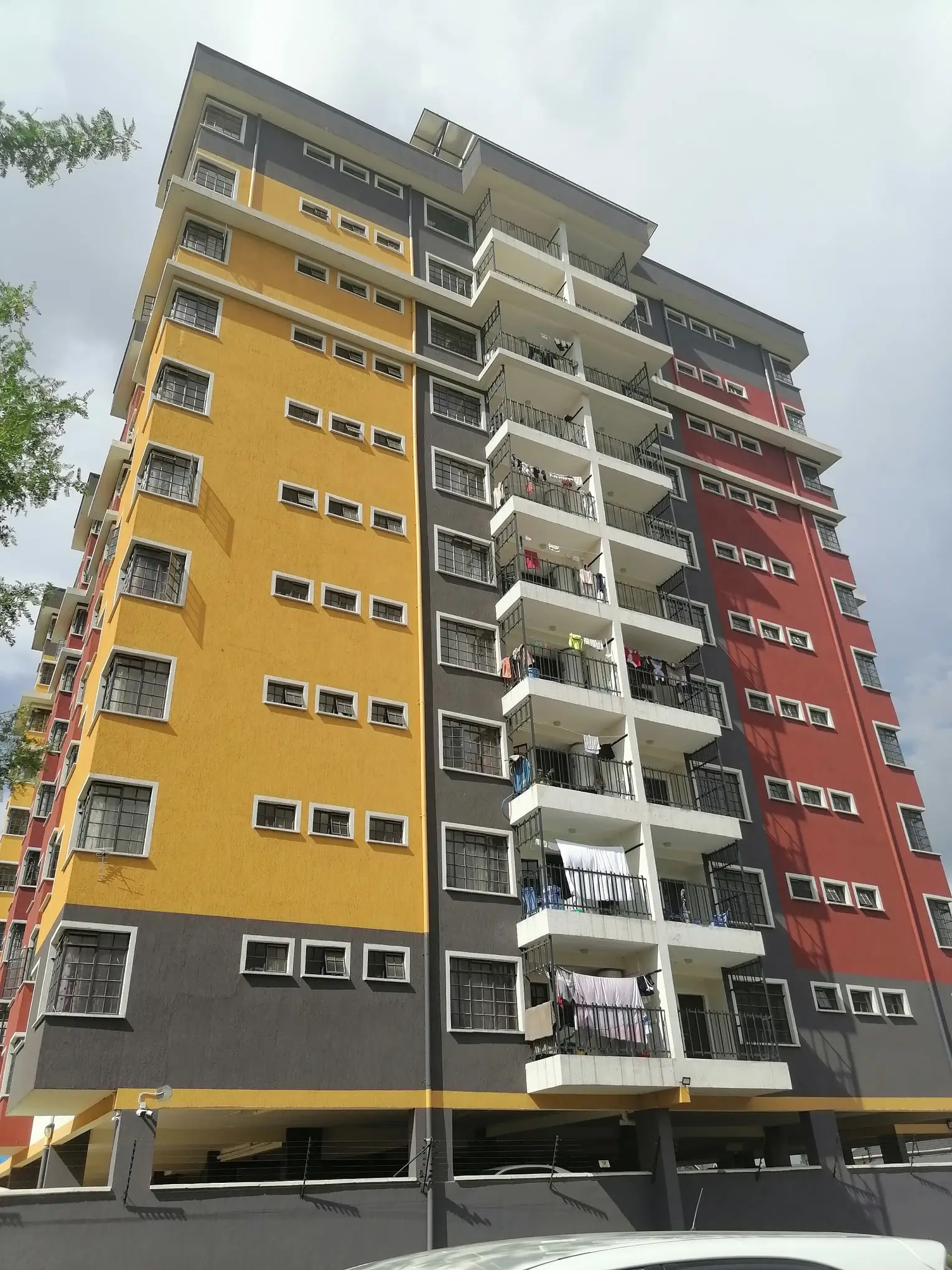 Multi-story apartment building with yellow, dark, and red facade