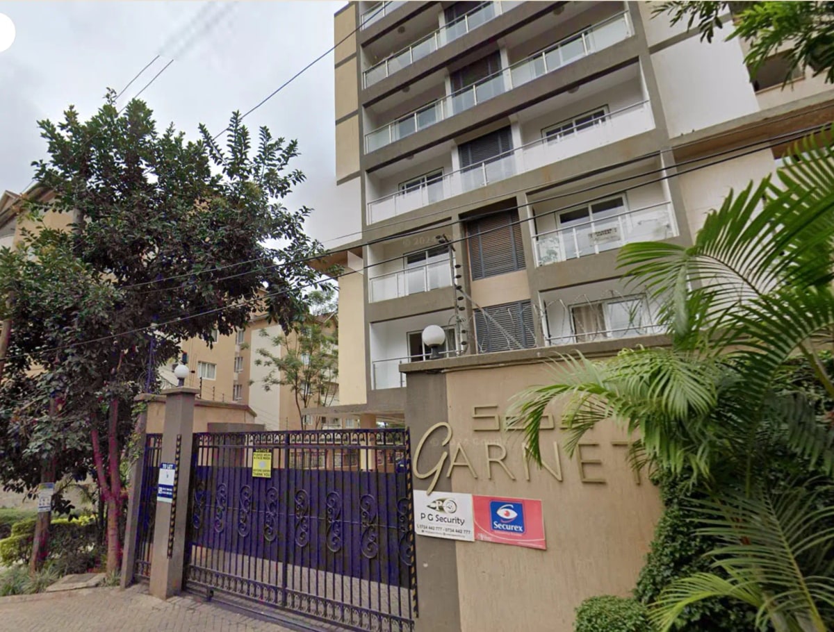 Multi-story residential building with gated entrance and compound