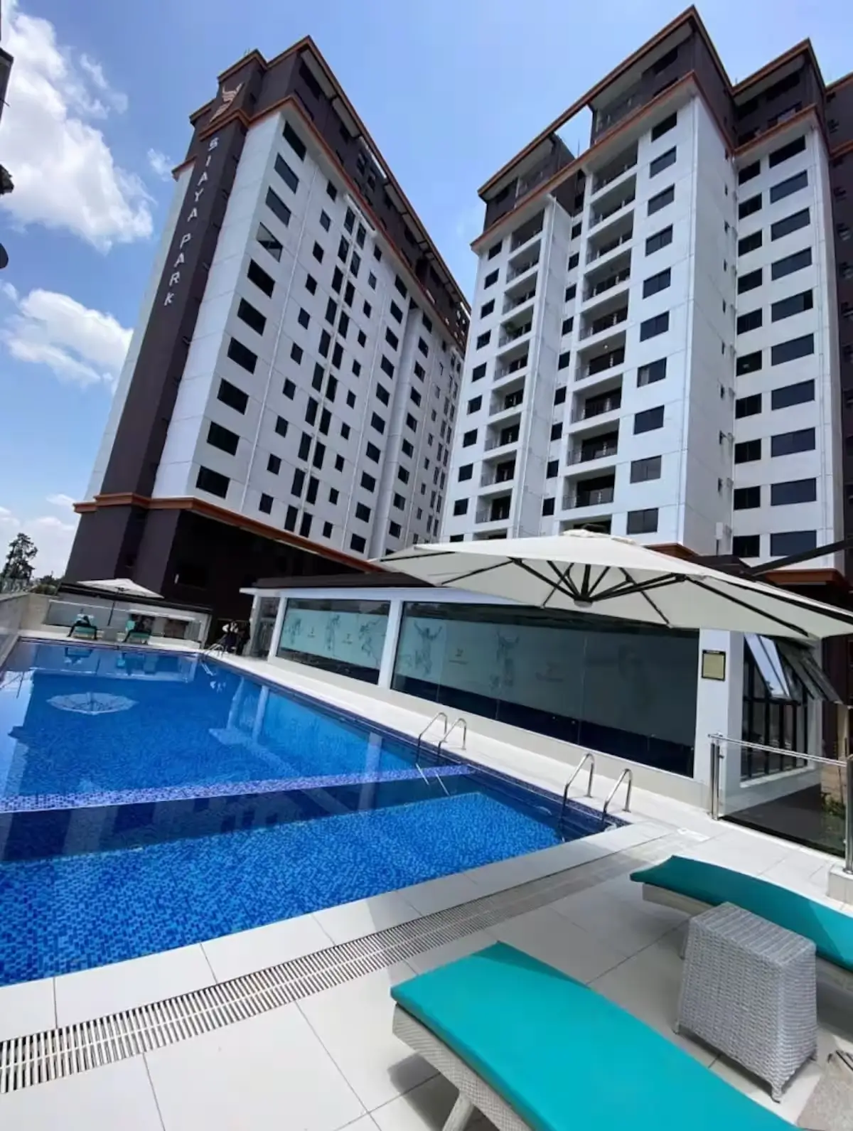 Resort-style swimming pool with loungers and residential towers