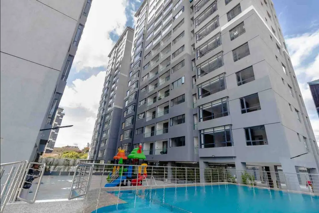 Rooftop pool with colorful play structure and residential tower