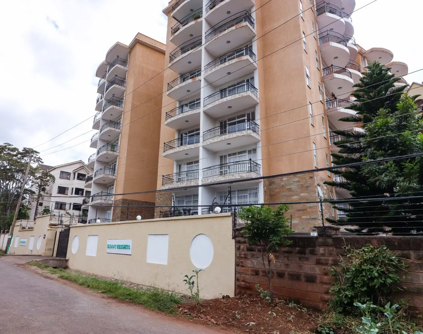 Multi-story residential building with balconies and perimeter wall
