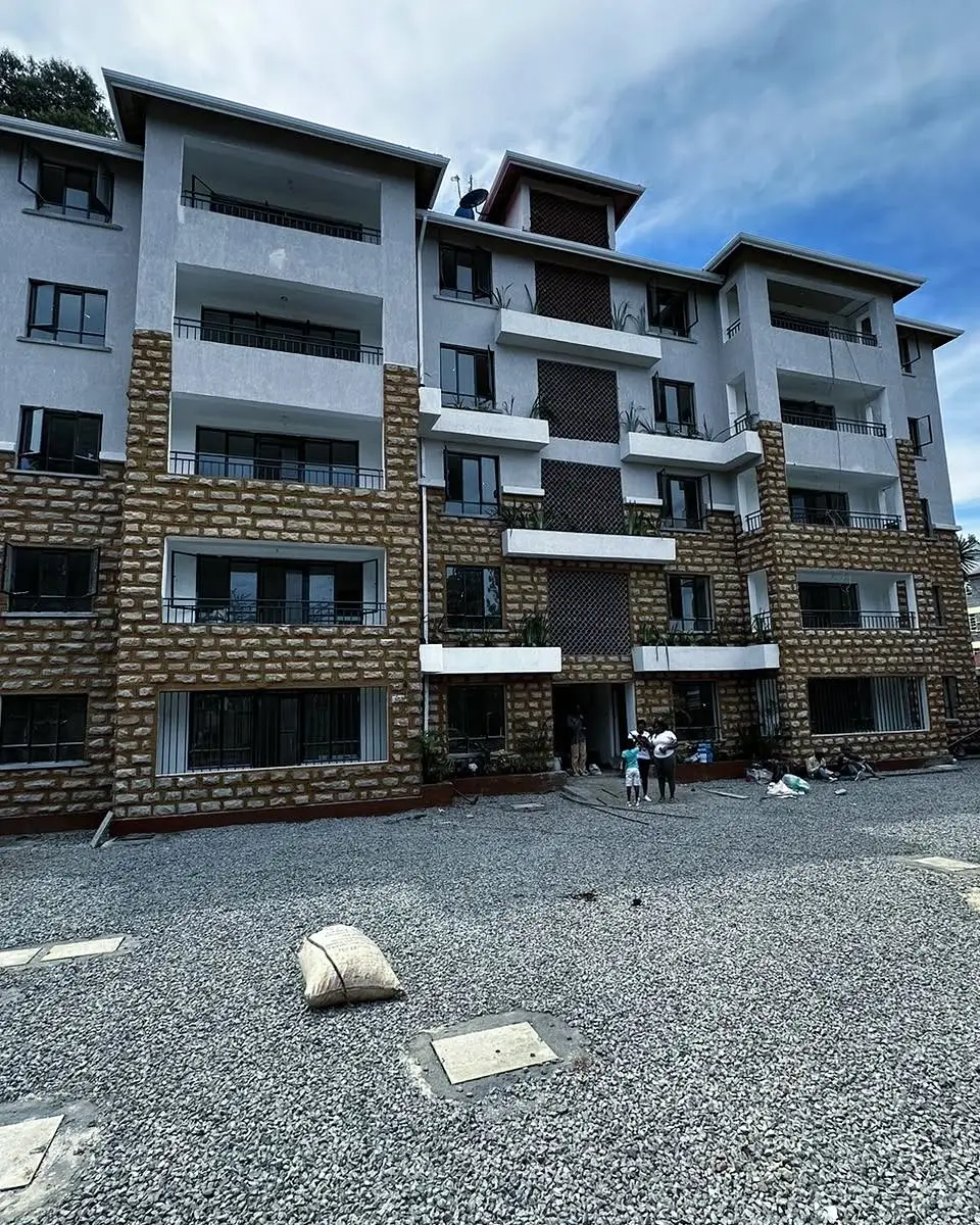 Modern multi-story apartment building with stone facade and balconies
