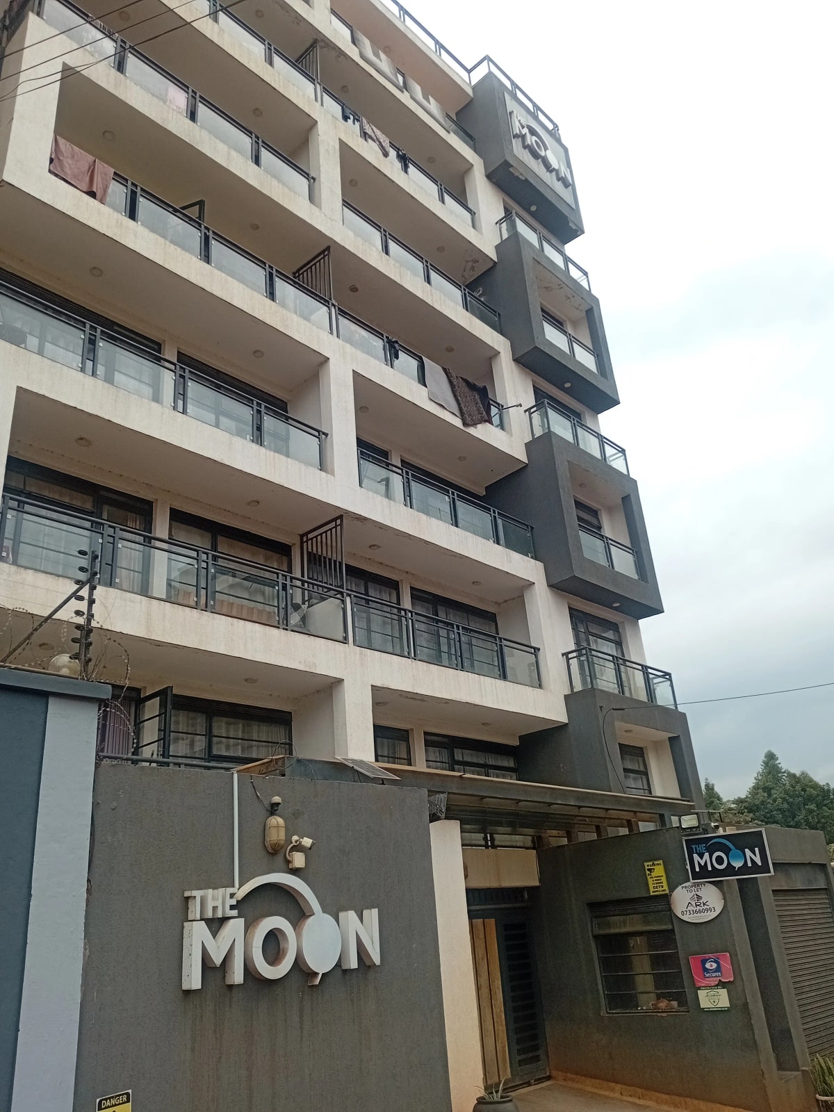 Modern multi-story residential building with balconies and ground-floor commercial space