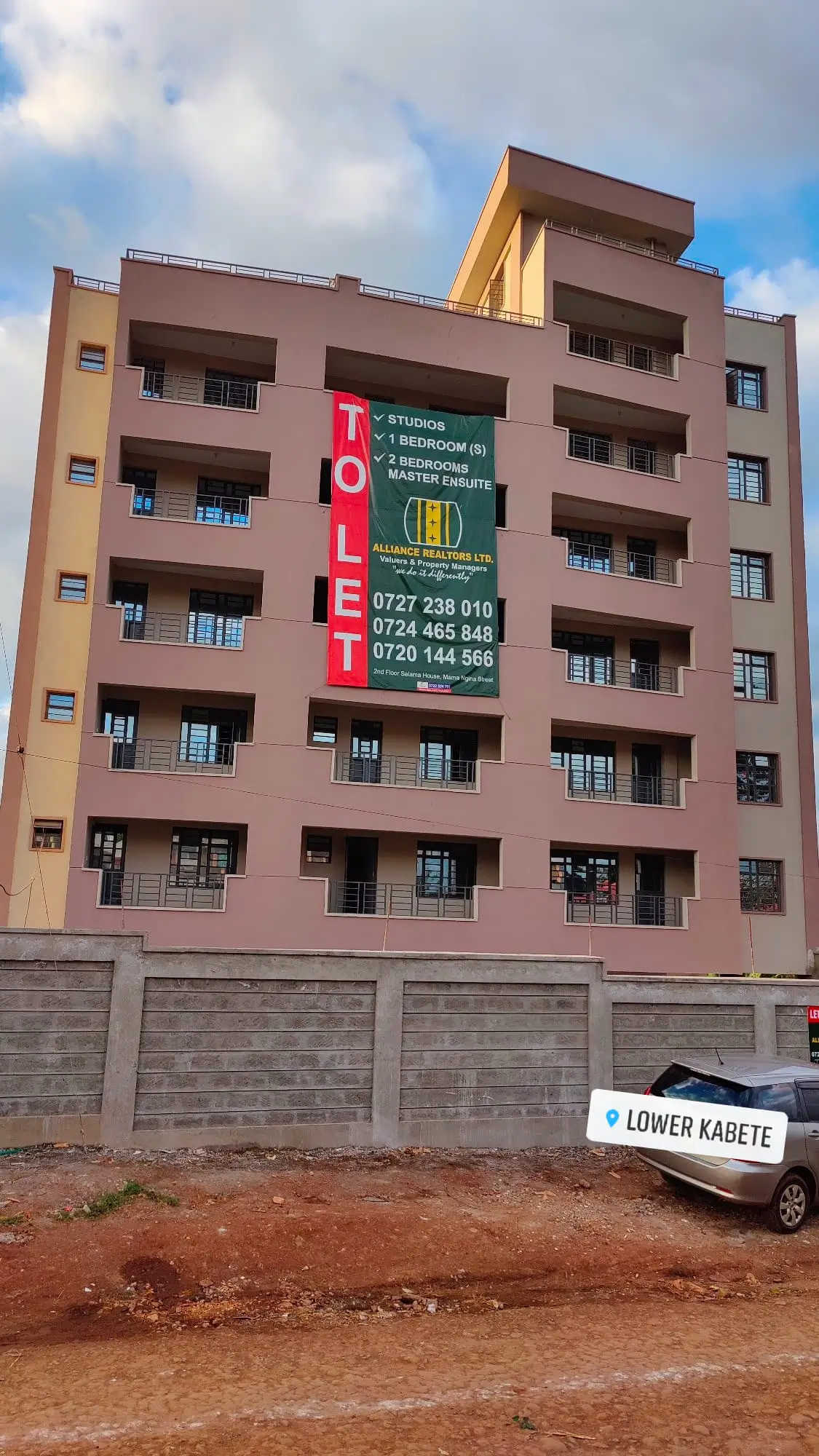 Multi-story residential building facade with ground-level parking