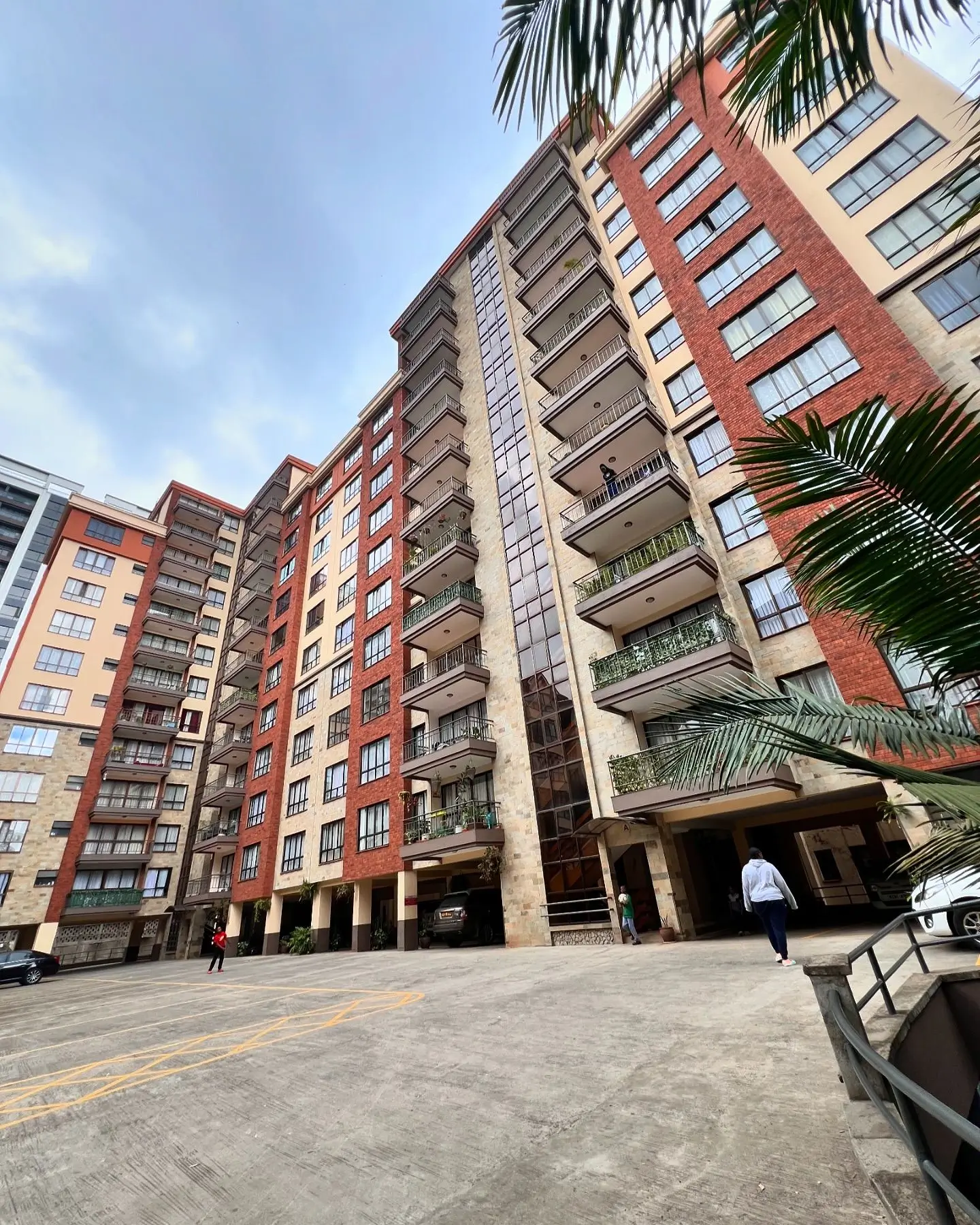 Modern multi-story residential building with red brick facade