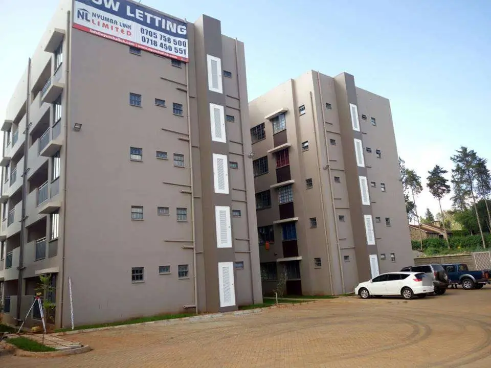 Multi-story residential building with parking area and signage