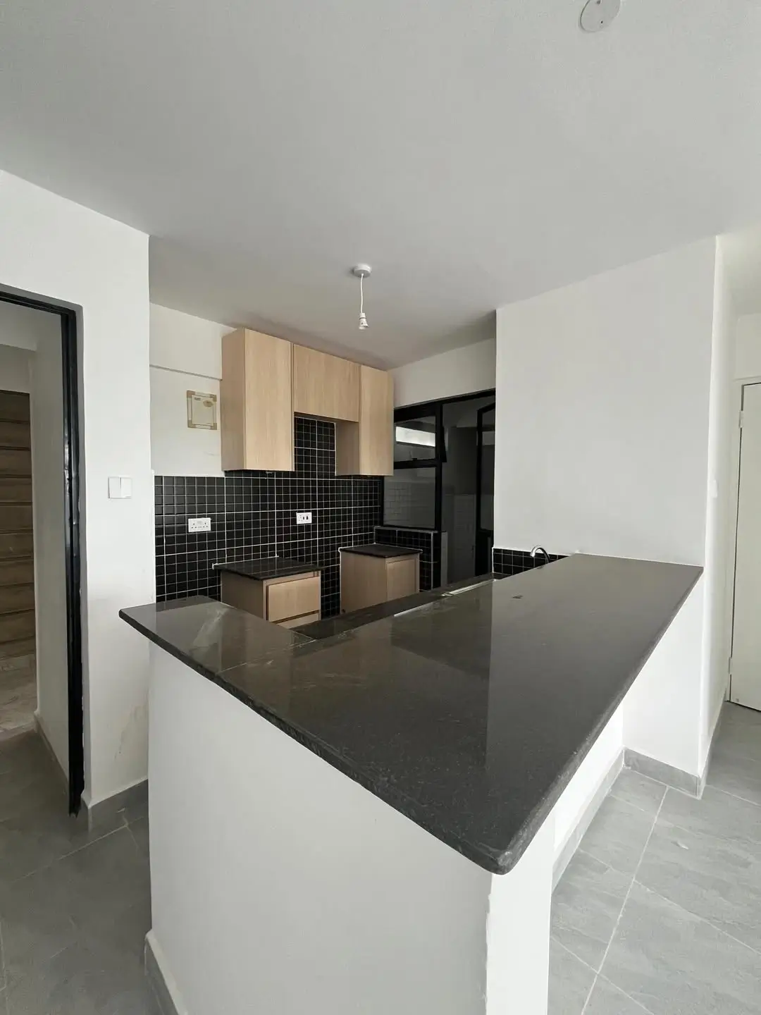 Modern kitchen with black tile backsplash and dark countertop