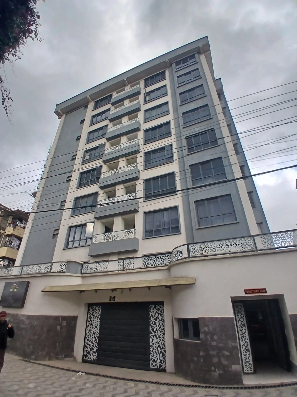 Modern multi-story residential building with ground-floor parking bays