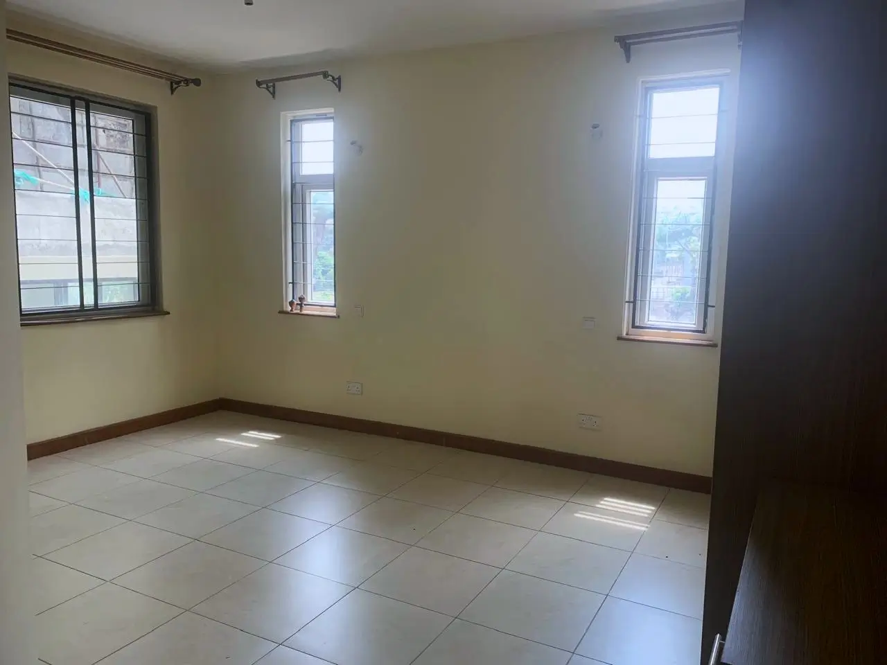 Spacious empty living room with tile flooring and natural light
