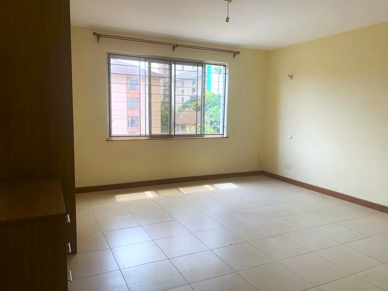 Bright living room with large windows and tiled flooring