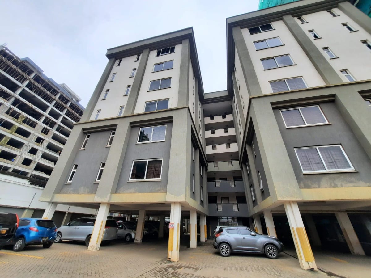 Modern apartment complex with ground-level parking bays