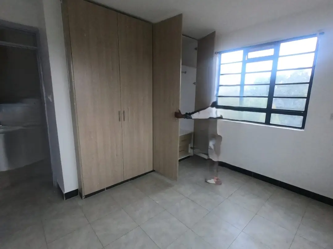 Unfurnished bedroom with built-in wardrobe and natural light