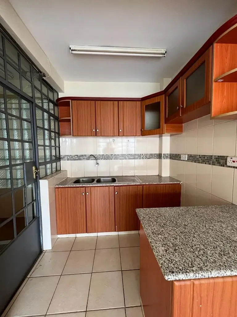 Warm wood-finished kitchen with granite countertop and gas cooktop