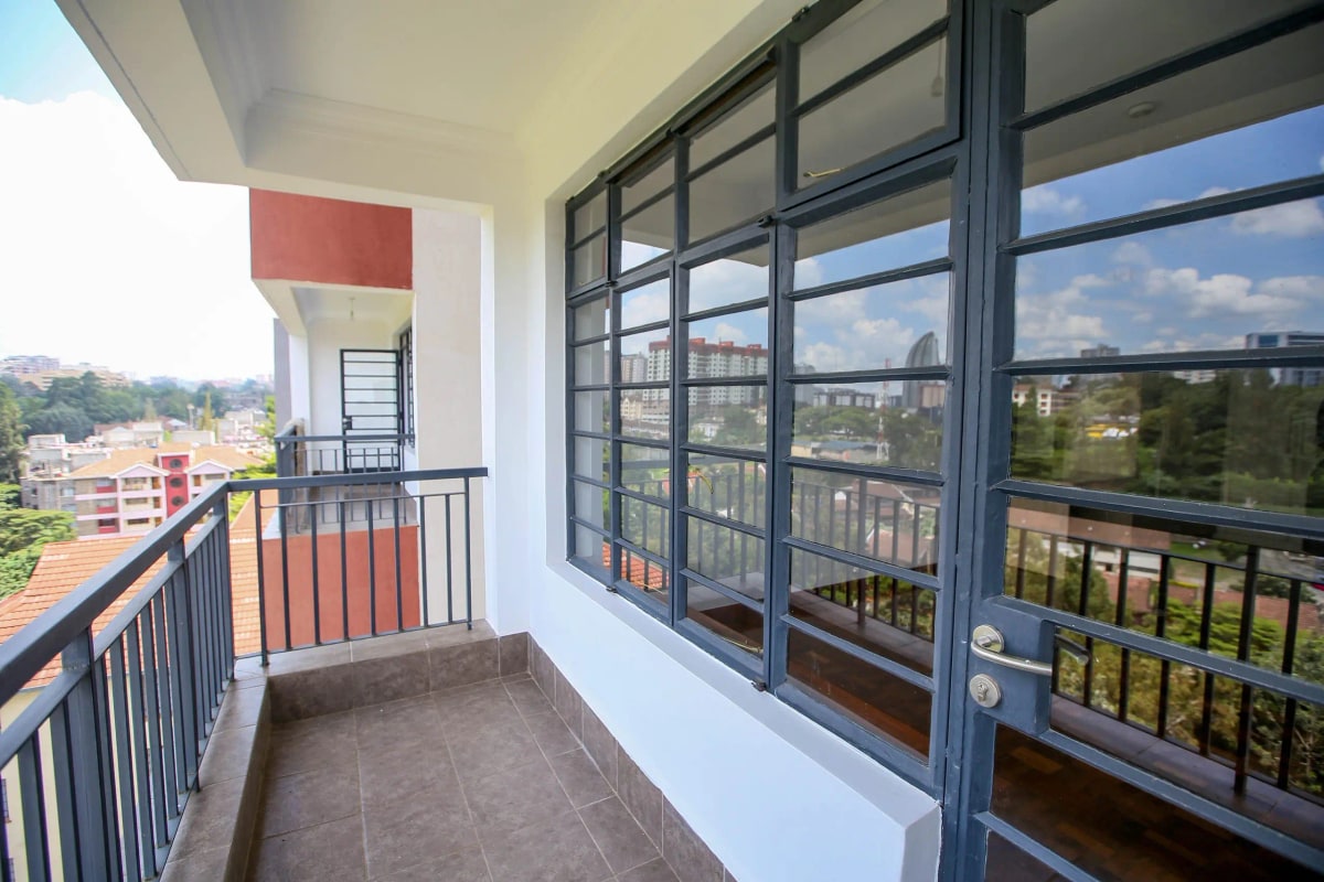 Spacious balcony with city and landscape views, metal railings