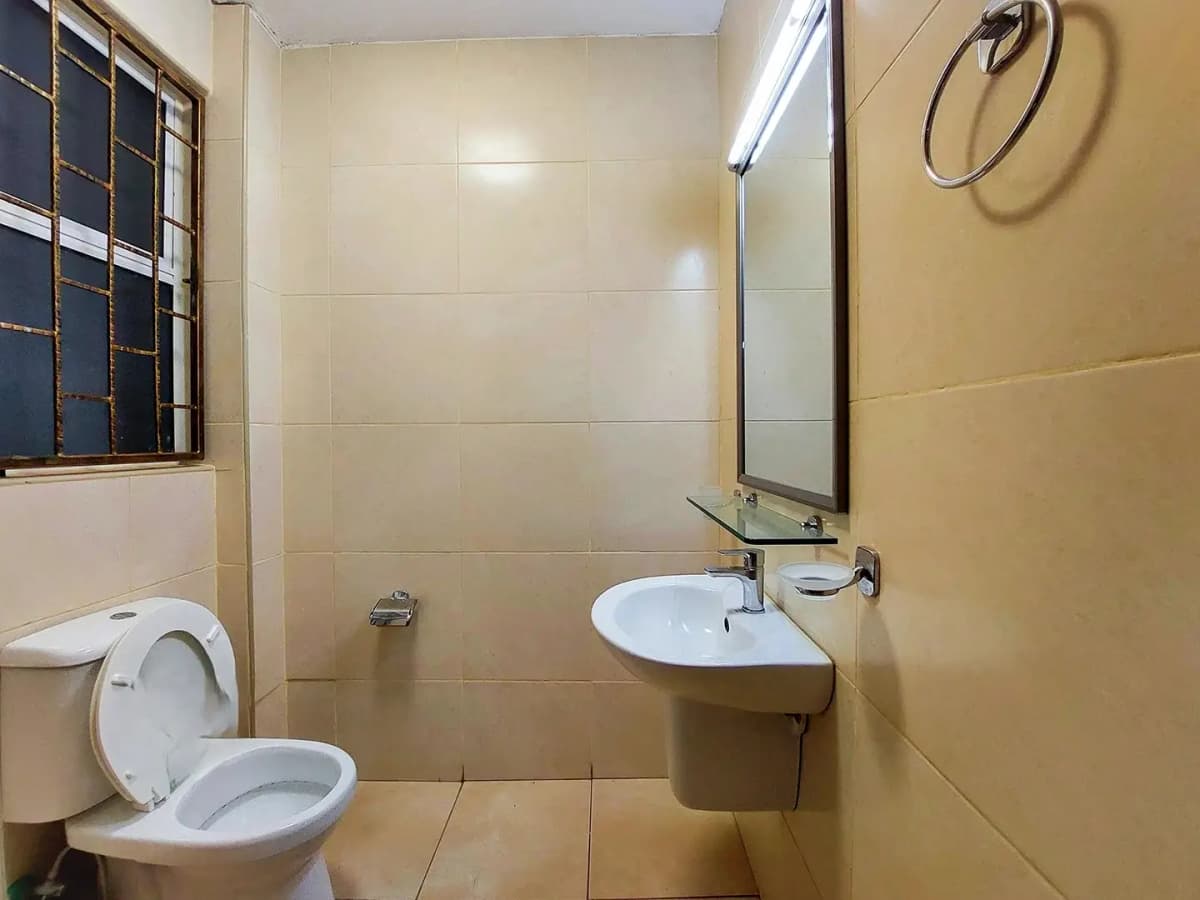 Compact bathroom with toilet, sink and shower area