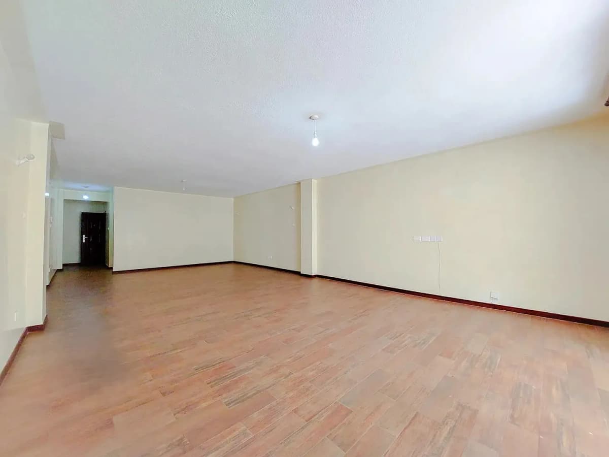 Spacious empty living room with wooden flooring throughout