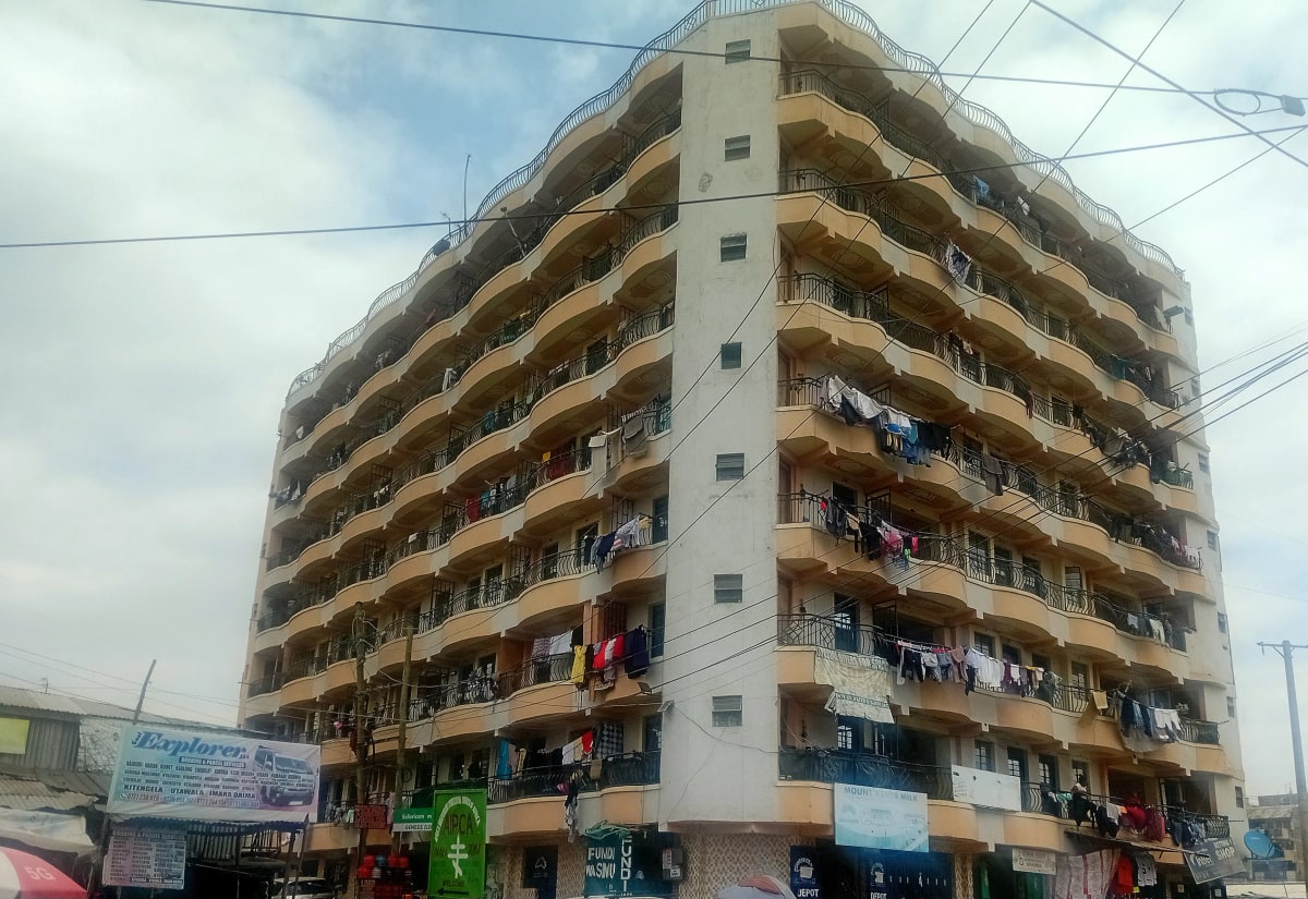 Multi-story residential building facade with balconies and street level shops