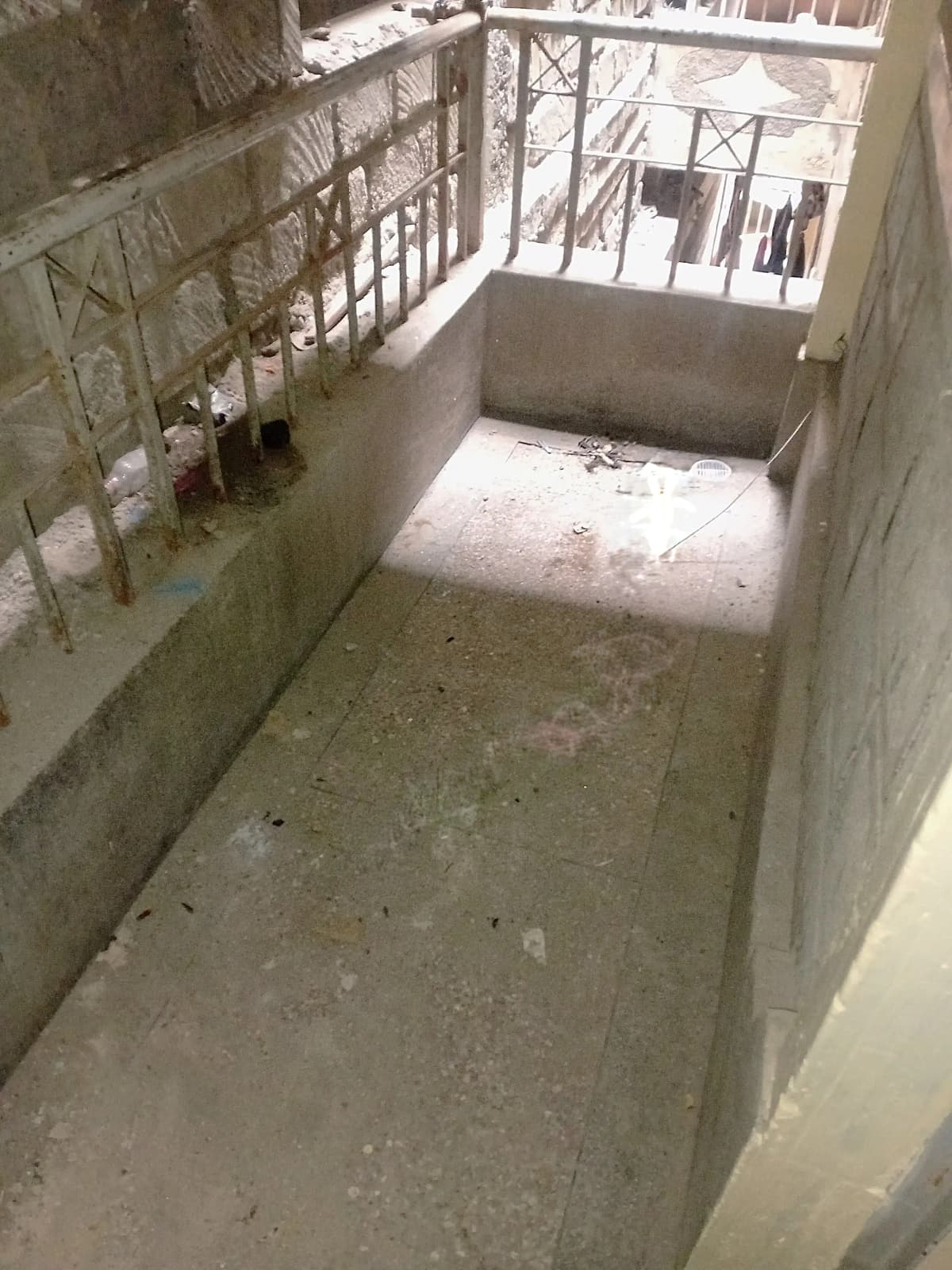 Concrete balcony with metal railing, unfinished surface