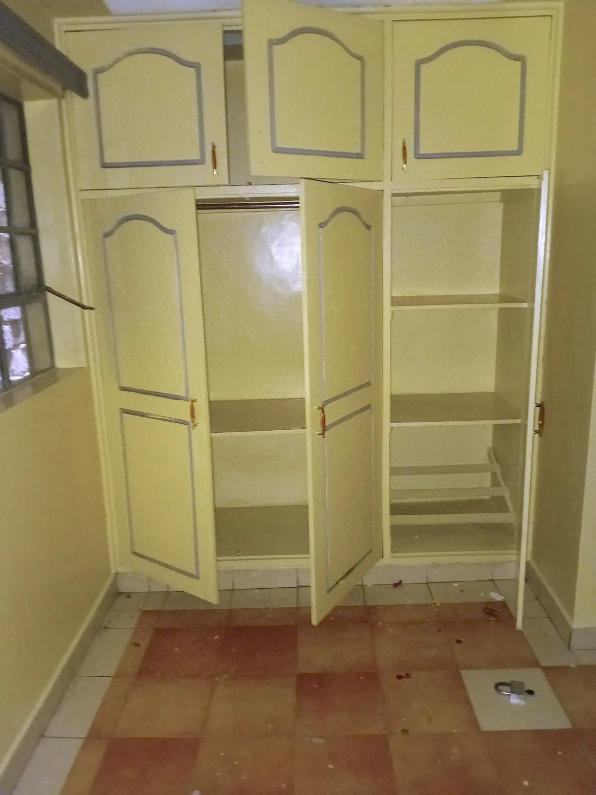 Yellow built-in pantry with open doors and shelving storage