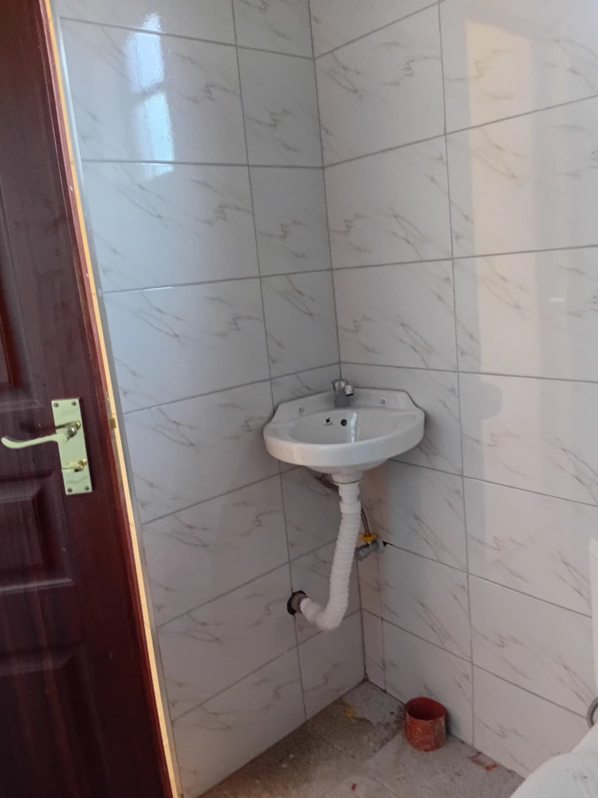 Bathroom with pedestal sink and tiled walls