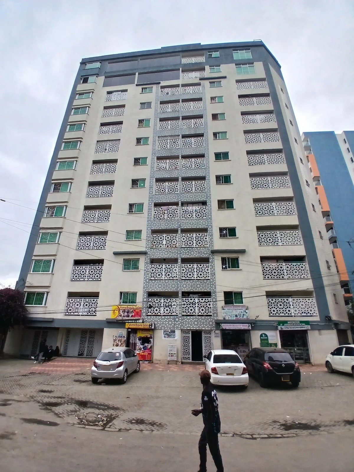 Multi-story residential building facade with balconies and parking