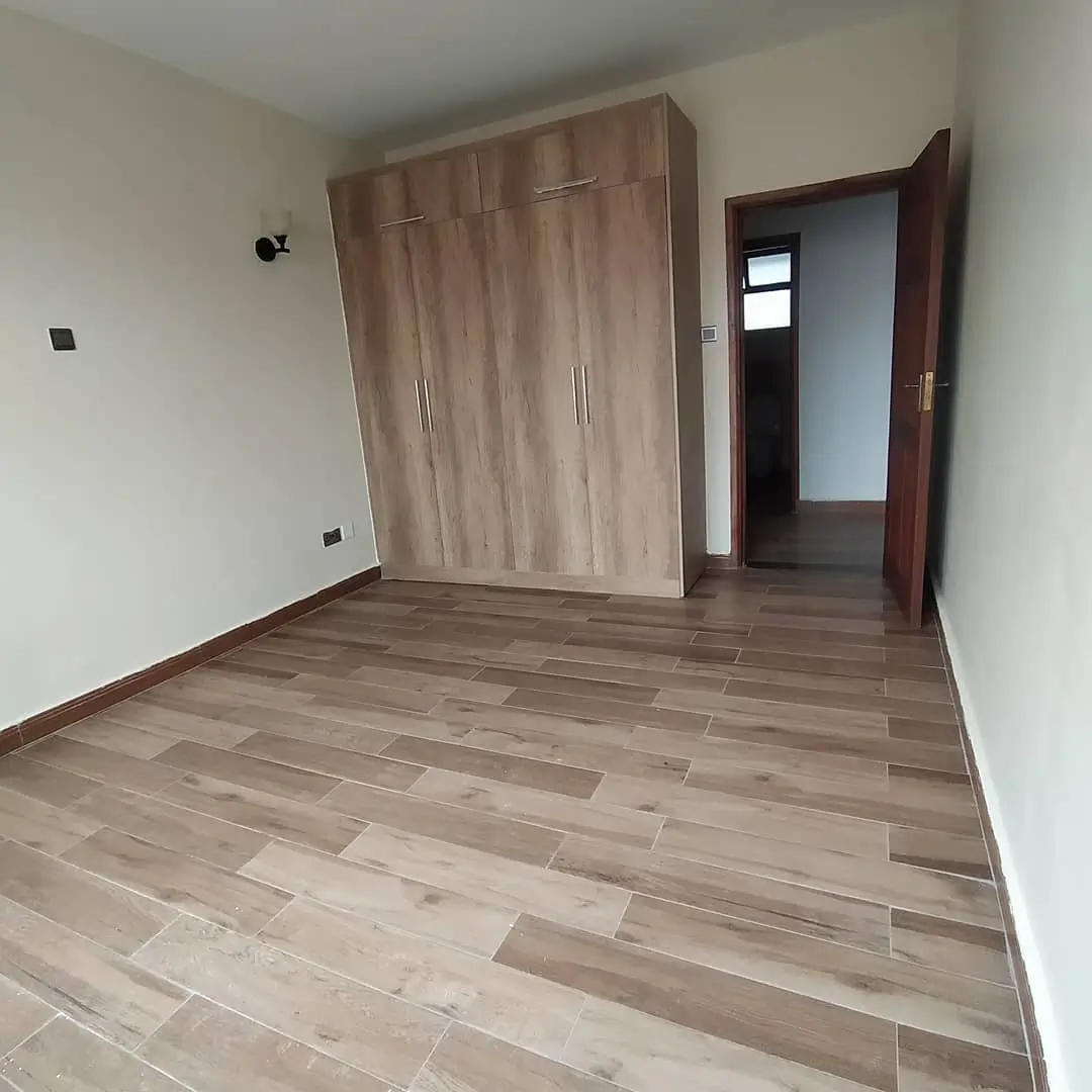 Spacious bedroom with built-in wardrobe and wooden flooring