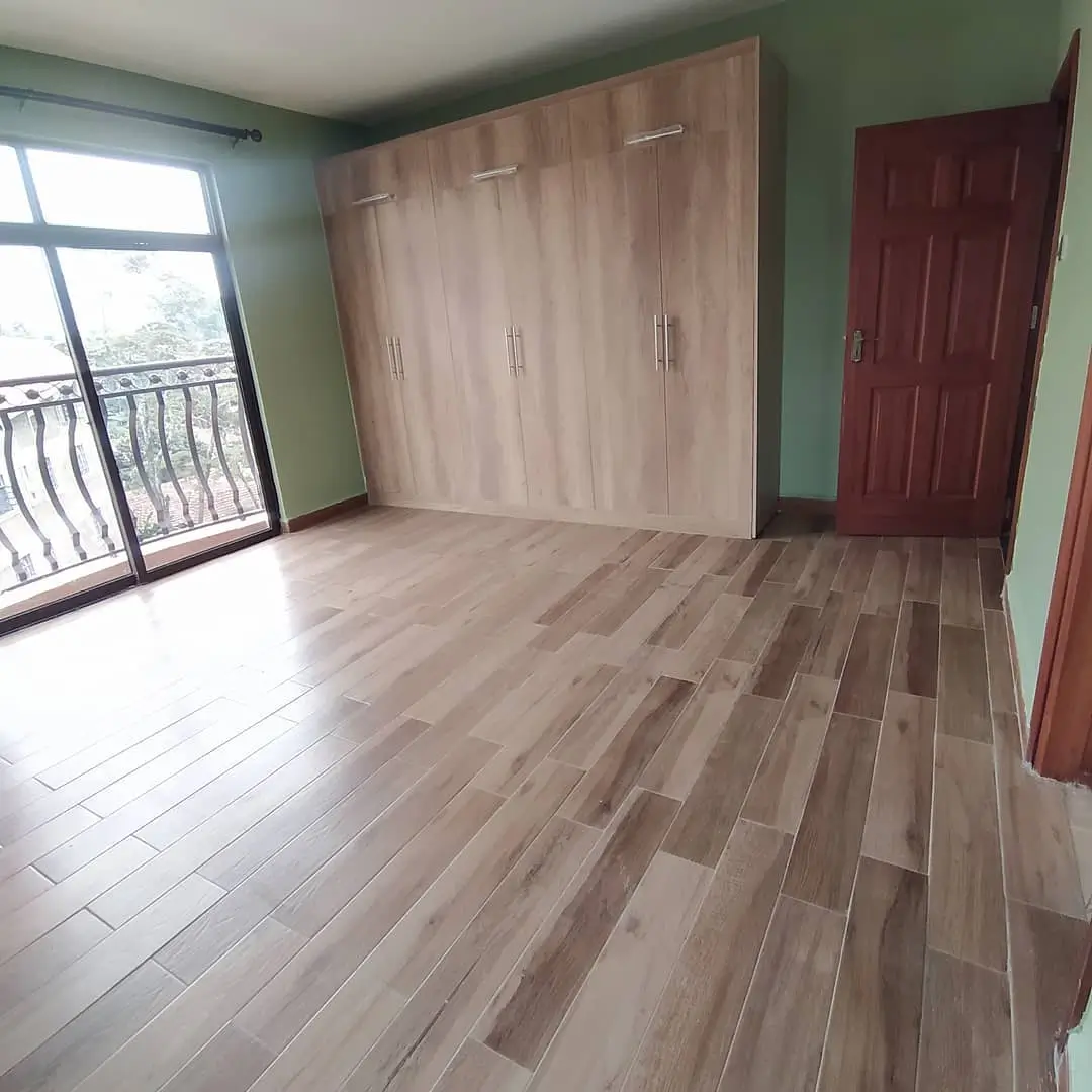 Spacious bedroom with wooden flooring and built-in wardrobes