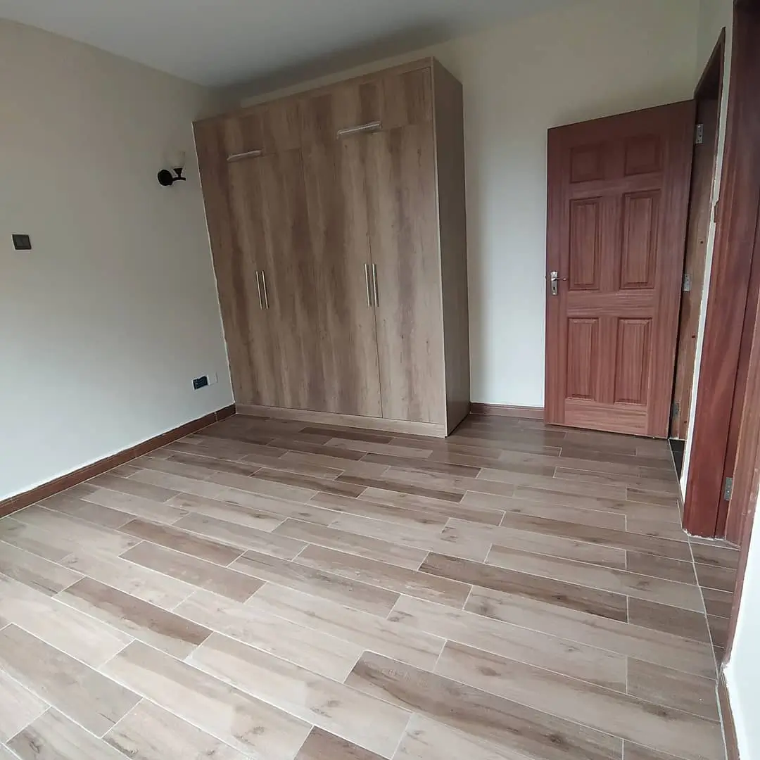 Spacious bedroom with wooden wardrobe and wooden flooring