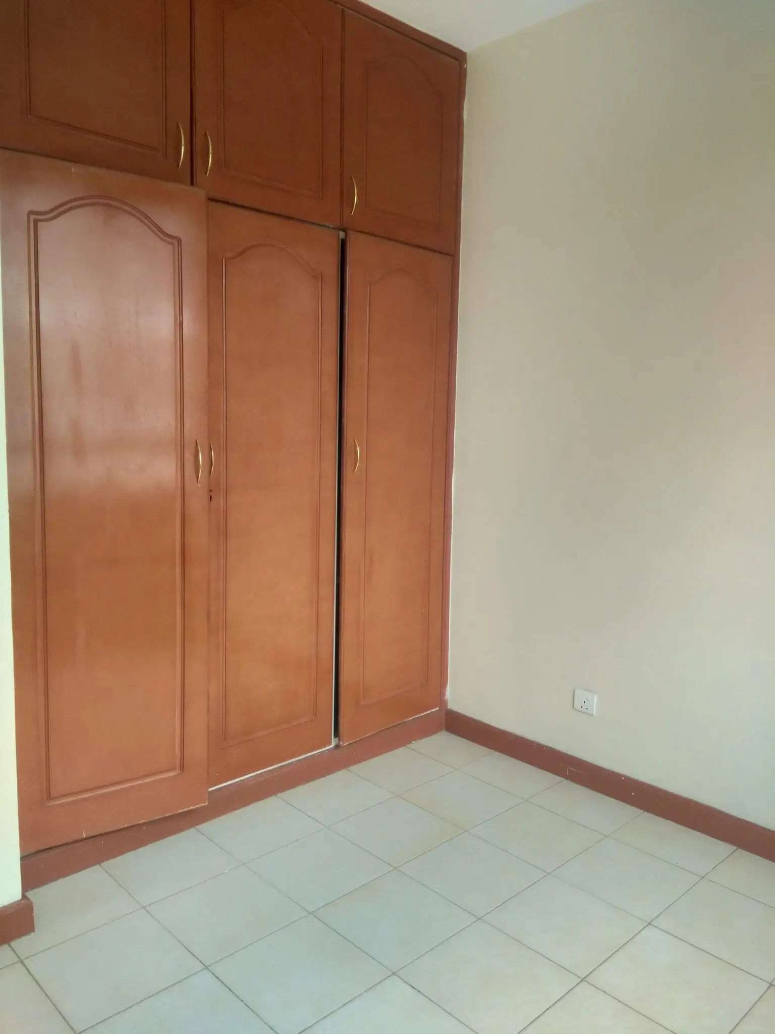 Bedroom with wooden built-in wardrobe and tiled flooring
