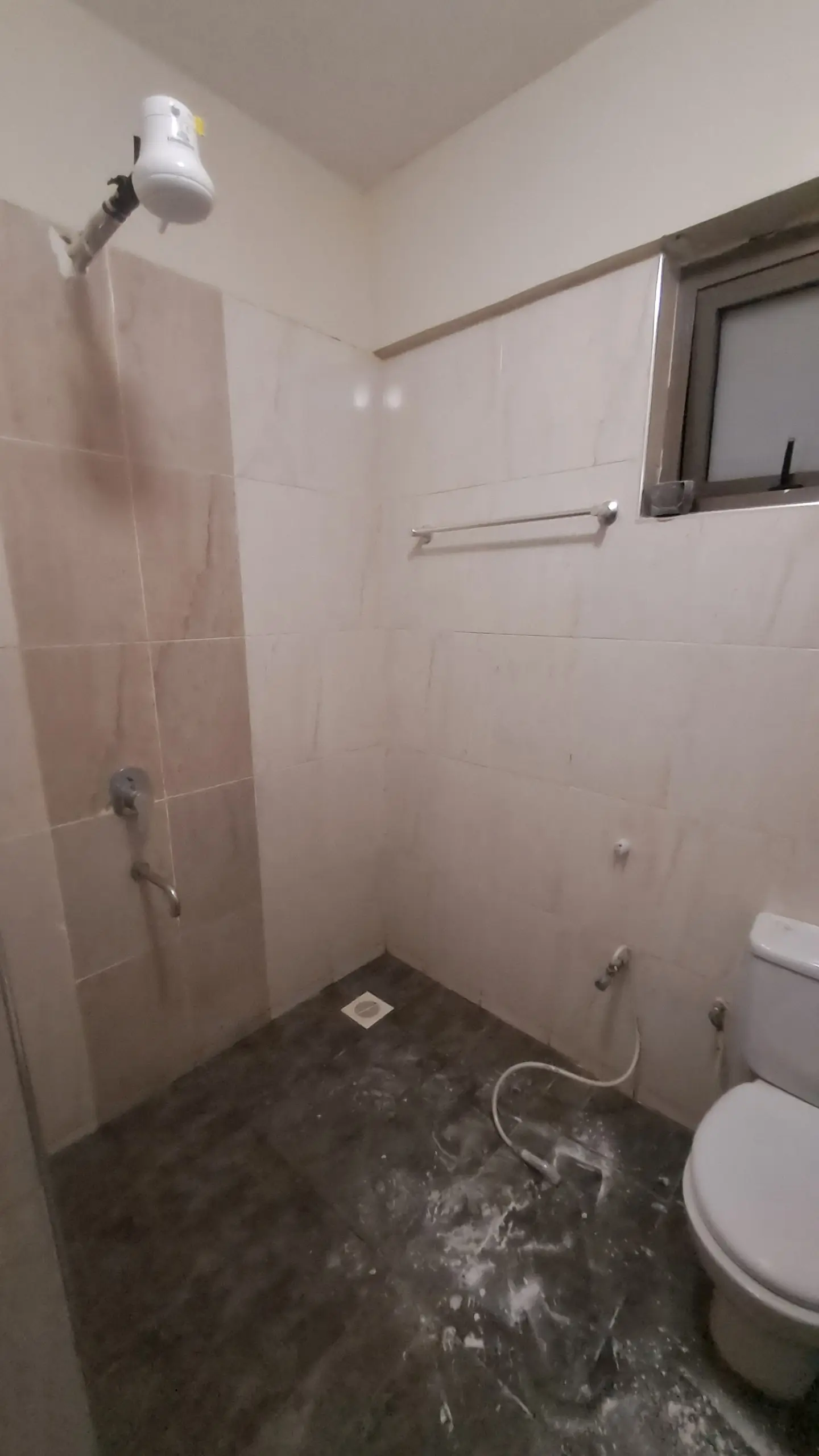 Bathroom with shower cubicle, toilet, and dark tile flooring